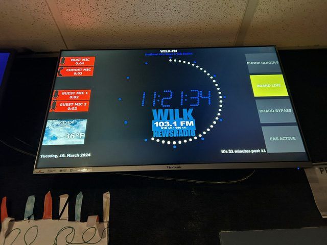 OnAirScreen on a studio monitor at WILK-FM: digital clock, four mic timers, and status LEDs
