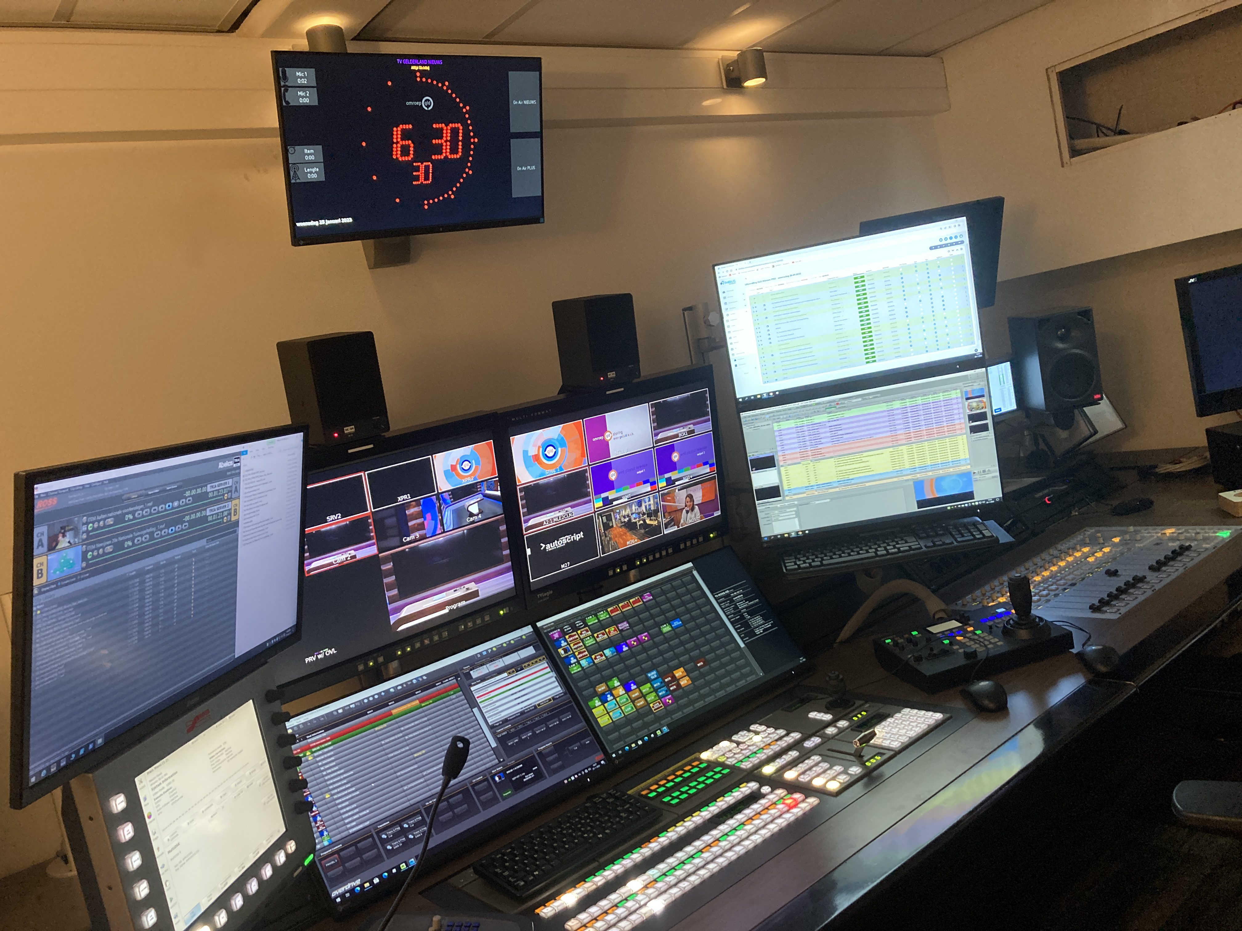 TV gallery with multiview monitors, mixing desk, and OnAirScreen countdown on the wall